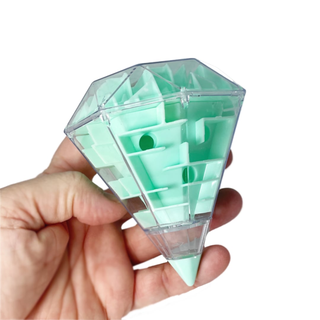 A hand holding a light green diamond shaped toy maze.