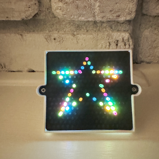 The World's Smallest Lite-Bright showing a star pattern lights up a dark area near some white brick.