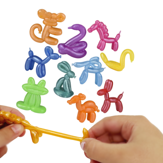 Hands stretch a golden unicorn balloon animal while several other small balloon animals are behind.