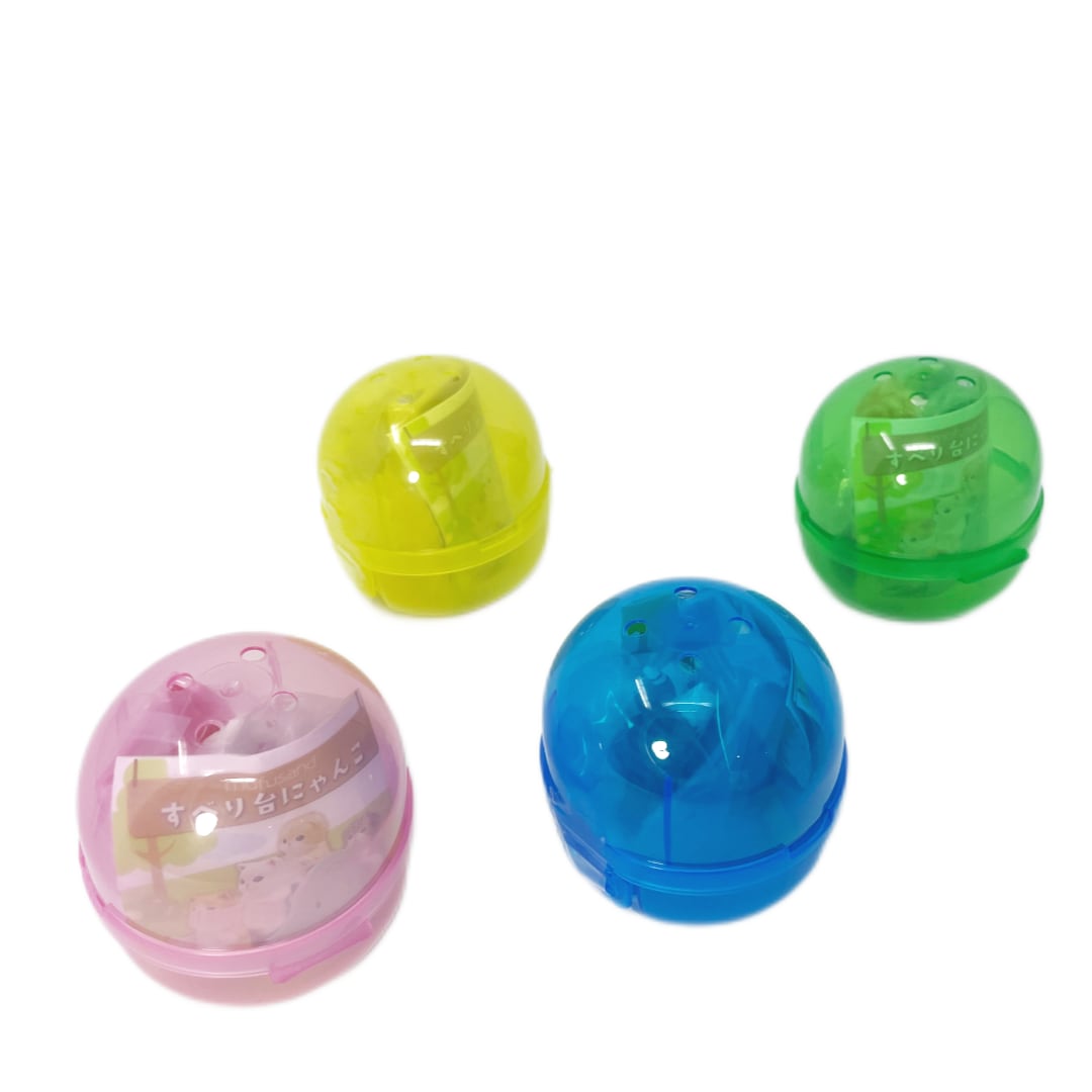 Four colorful capsule toys with toy cat and slide figurines inside.