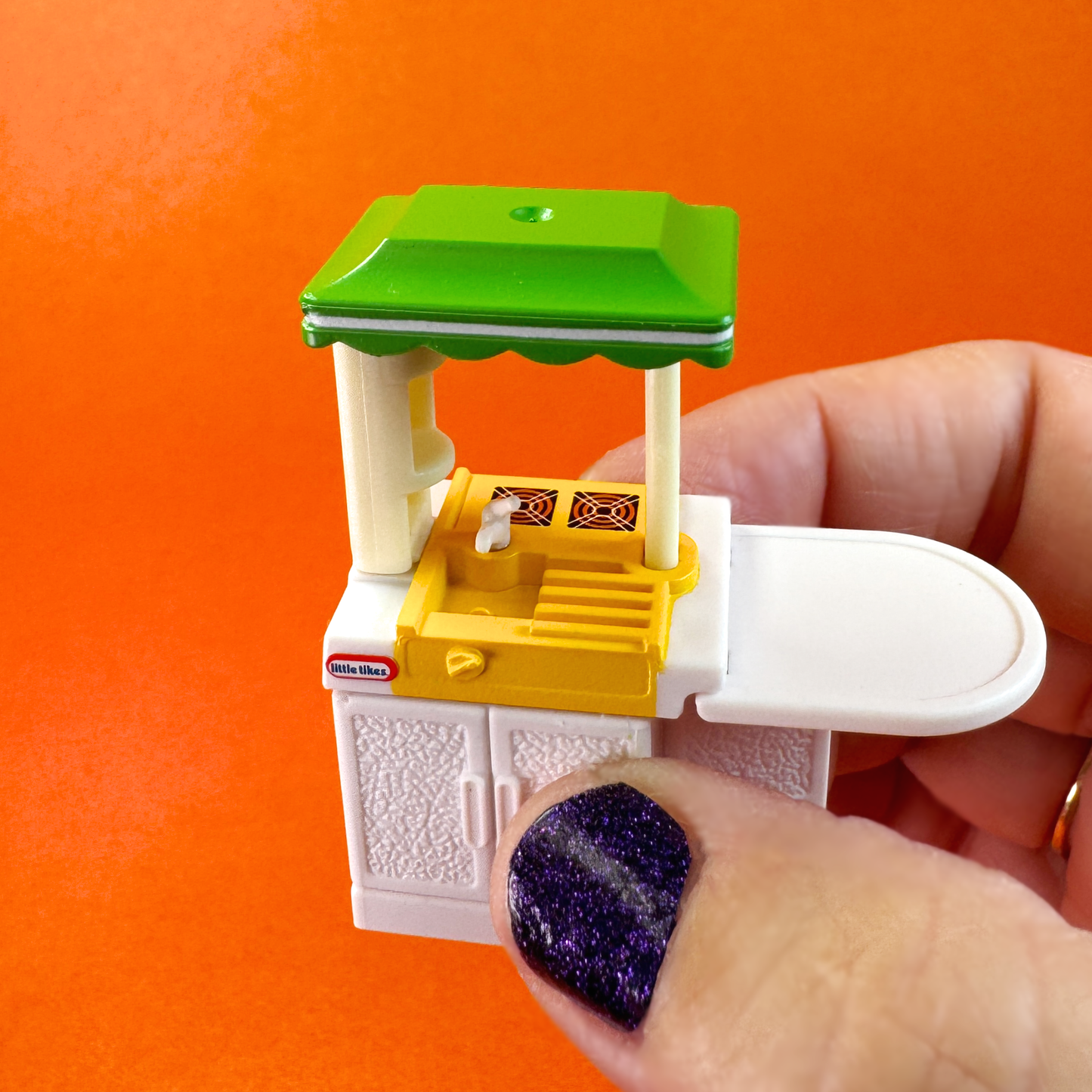 A hand holds a miniature Party Kitchen from Miniverse Little Tikes minis