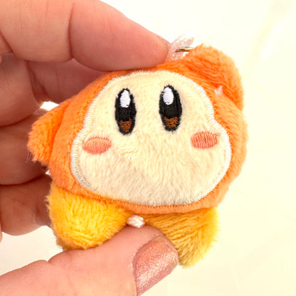 Small plush toy of Waddle Dee, held between fingers against a neutral background