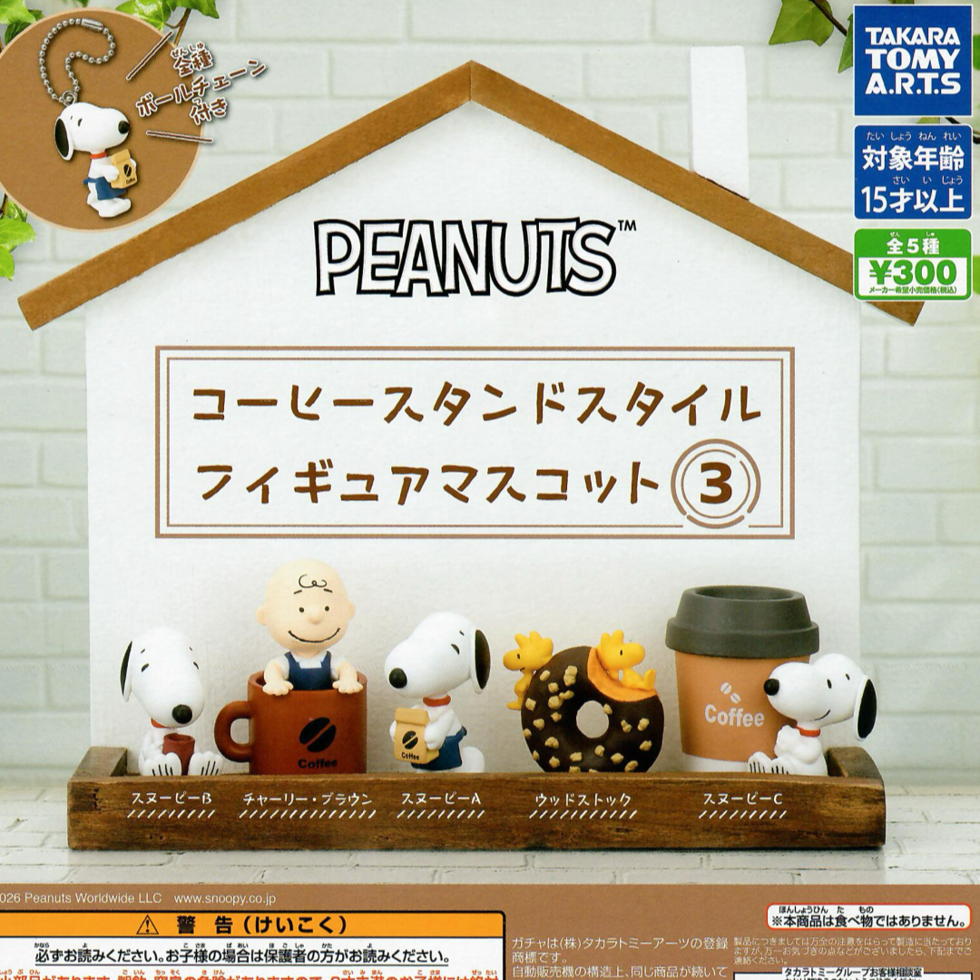 Peanuts coffee stand figurine set displayed on a wooden shelf against a white brick wall backdrop. The set includes five character figures and coffee-themed accessories, with Japanese text by Takara Tomy Arts
