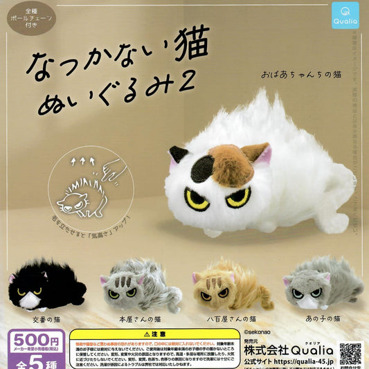 Promotional gachapon graphic for a cat-shaped plush toy set, showing an unfriendly white calico cat in the center with Japanese text, plus four smaller cat plush options at the bottom in black, gray, tan, and light gray. The Qualia brand logo appears in the top right corner.