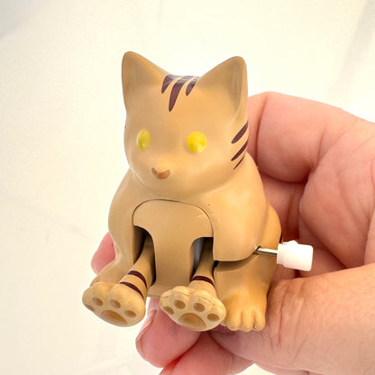 Cat-shaped toy held in a hand against a plain background