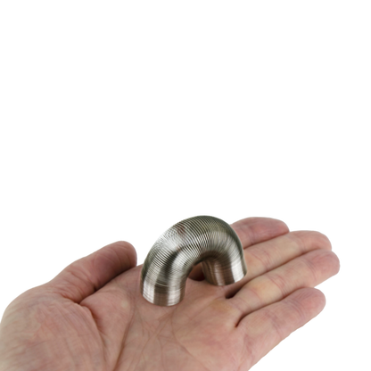 A tiny metal Slinky bounces across someones hand. 