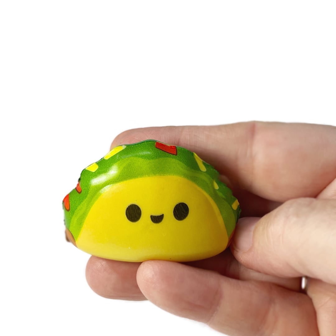 A handing holding a micro squishy taco fidget toy.
